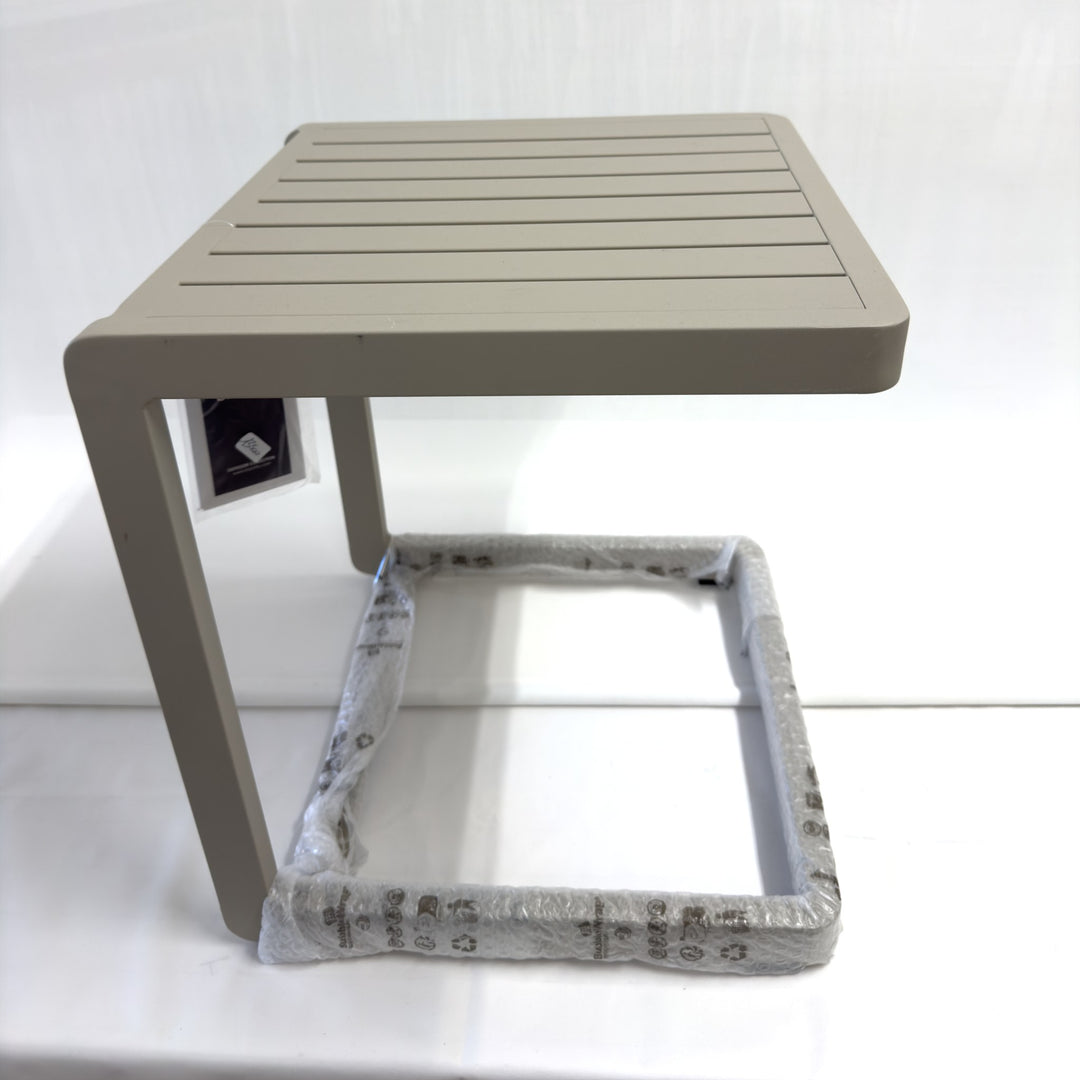 Tavolino Bizzotto Konnor 40×40 Rastin su sfondo bianco, di lato: la forma a C, con la base ancora nel film protettivo
