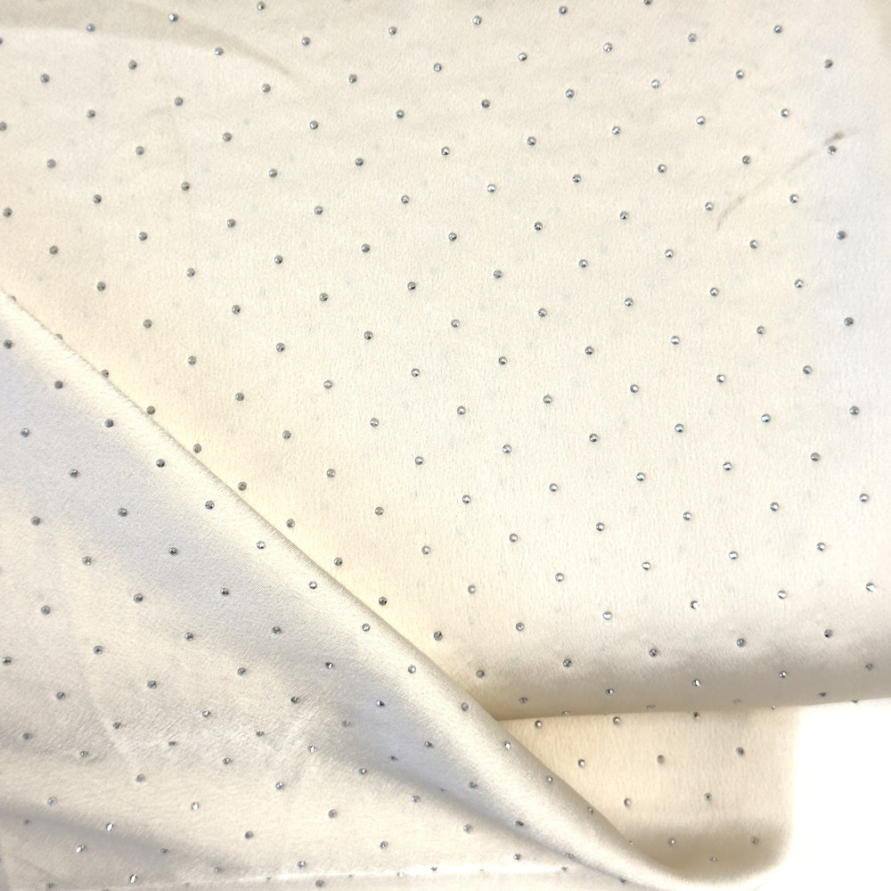 Tessuto bianco panna con brillantini argento, primo piano della superficie satinata