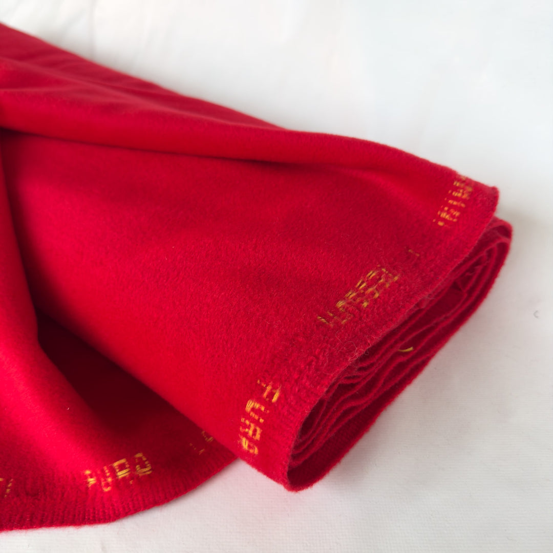 Tissu pour manteau rouge vif en laine et cachemire, plié, avec la lisière