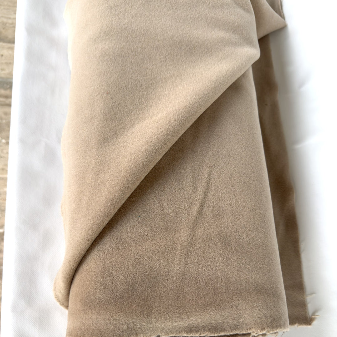Wool and cashmere coating fabric in sand, folded, on a white background