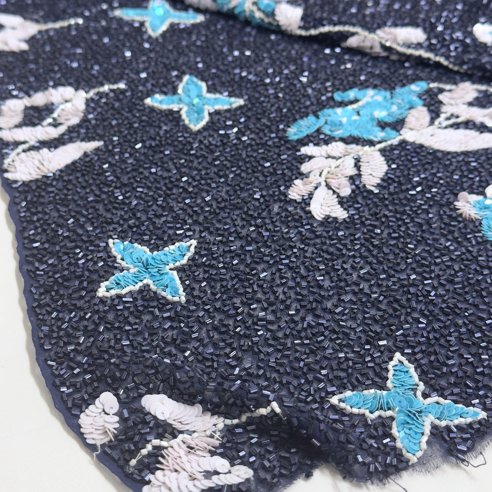Chiffon blu scuro coperto di perline, con stelle in paillettes turchesi