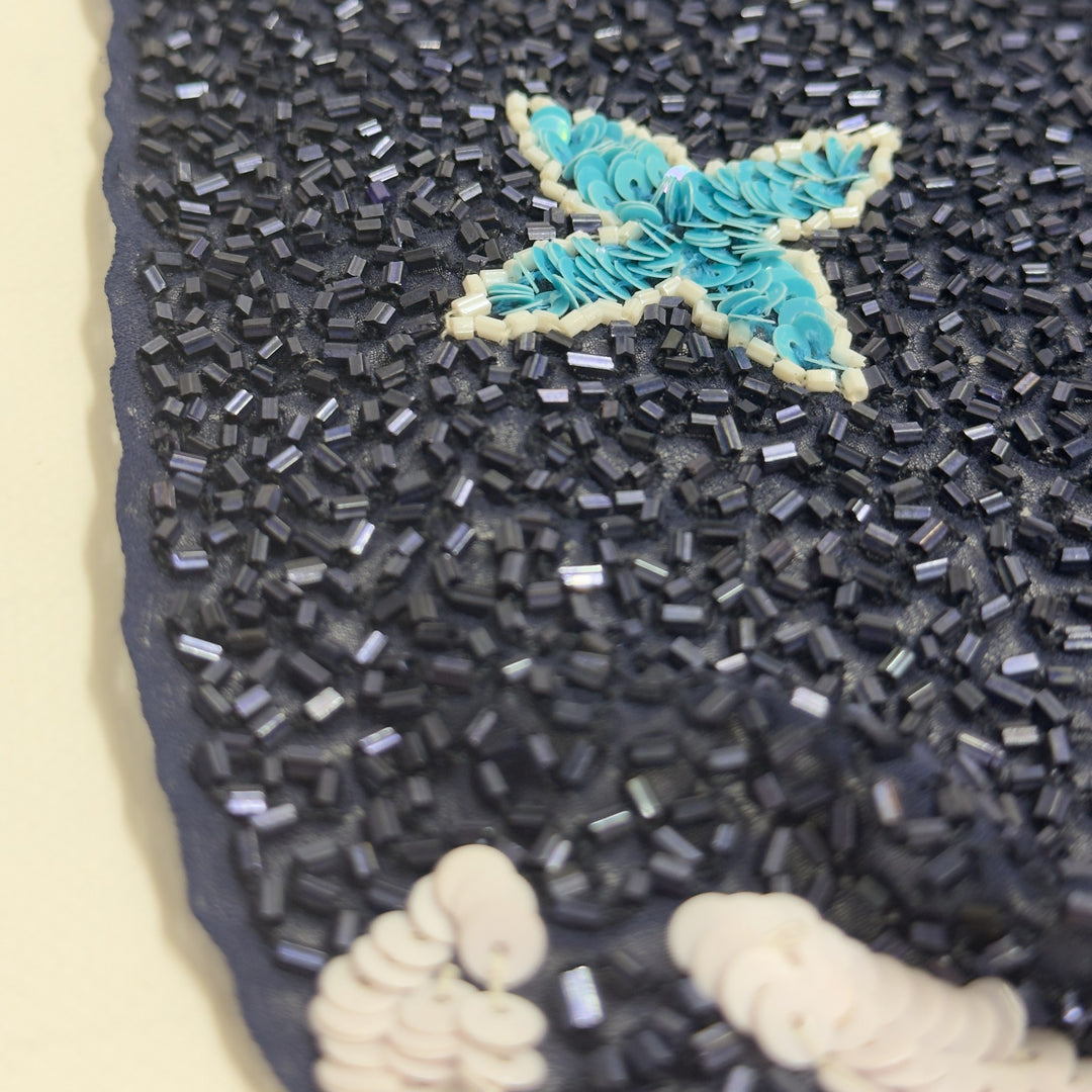 Detail of the tubular beads and a turquoise sequin star