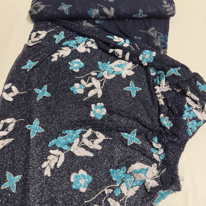 Embroidered dark blue chiffon fabric unwound from the roll