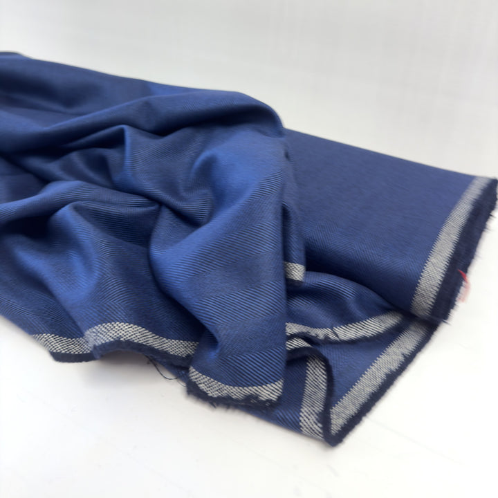 Blauer Fischgratstoff, drapiert, mit weiß-blauer Webkante