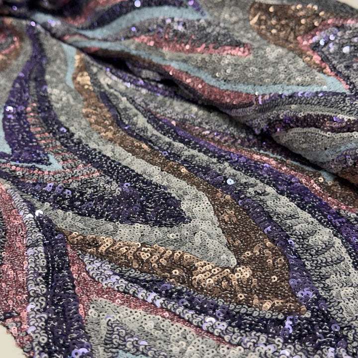 Détail de la broderie de petites paillettes en vagues multicolores