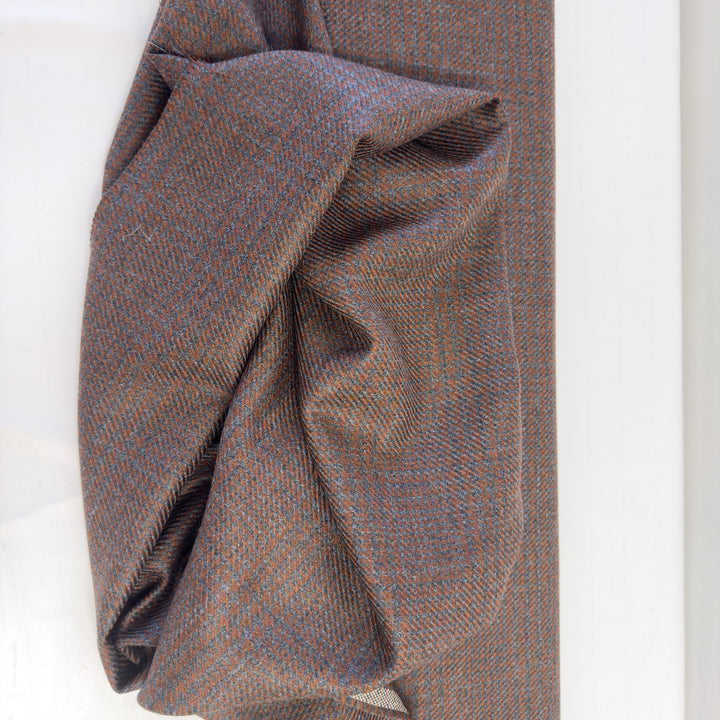 Tissu pied-de-poule marron et gris en laine, drapé pour en montrer le tombé