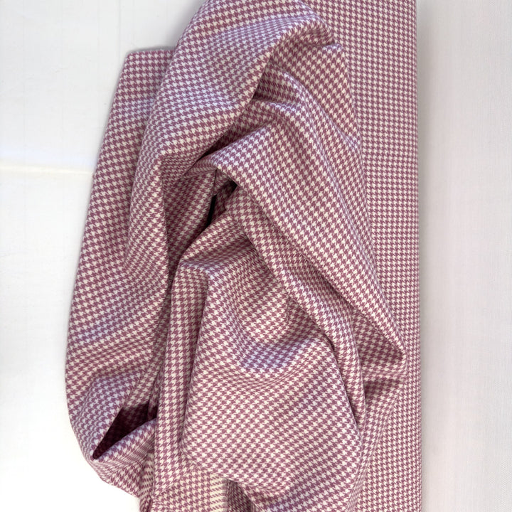 Tissu pied-de-poule rose étalé et drapé