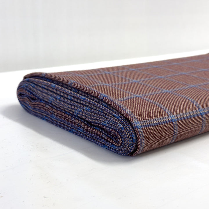 Bolt of reddish-brown and blue check fabric seen from the side