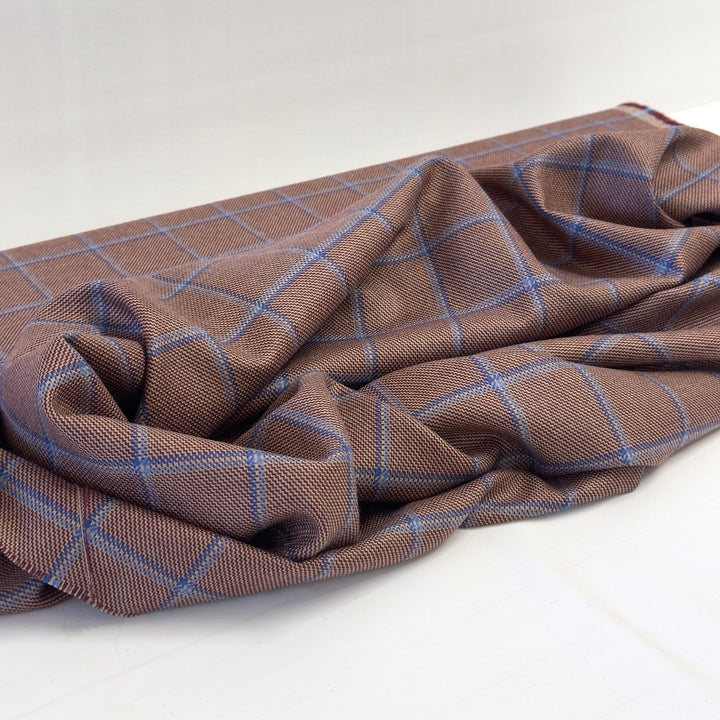 Reddish-brown and blue check fabric draped on a white background