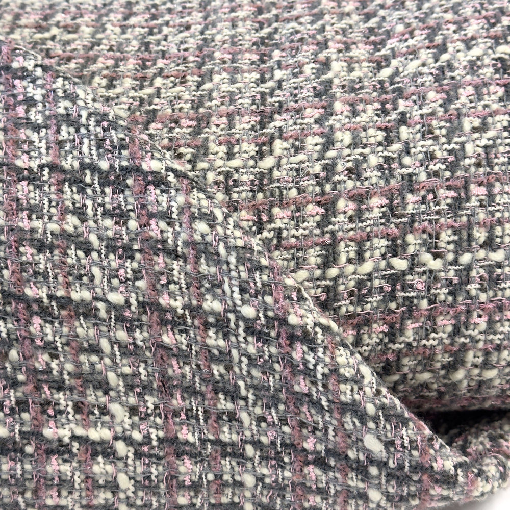 Bouclé-Struktur aus der Nähe: Garne in Cremeweiß, Grau und Rosa mit kleinen Noppen