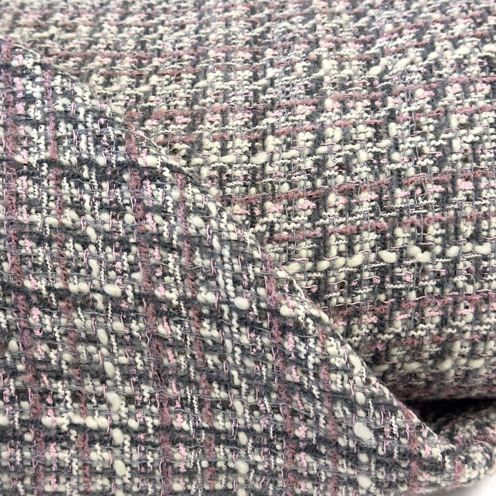 Close-up of the bouclé weave: cream, grey and pink yarns with small knots
