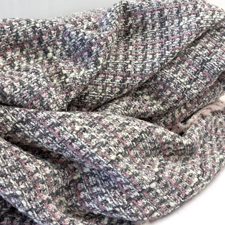Pink, grey and white bouclé check tweed, draped on a white background