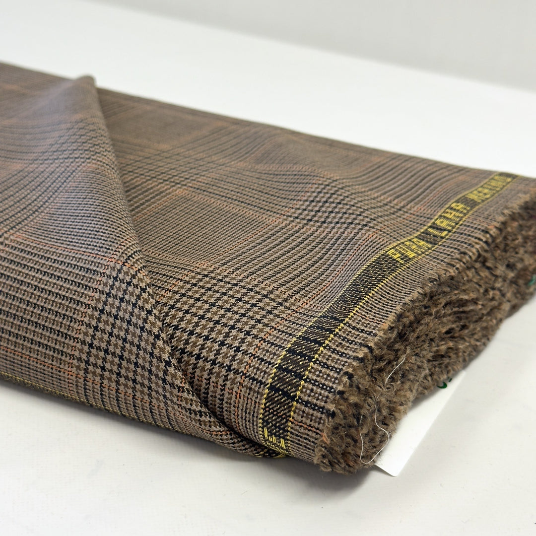 Lisière du tissu à carreaux marron avec l&