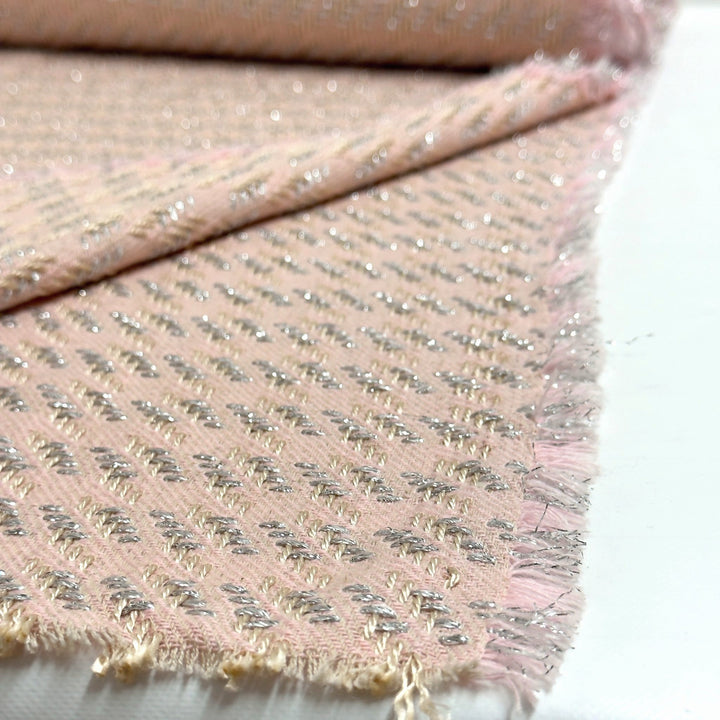 Close-up of the weave of the pink fabric: raised diagonal pattern with silver and cream threads