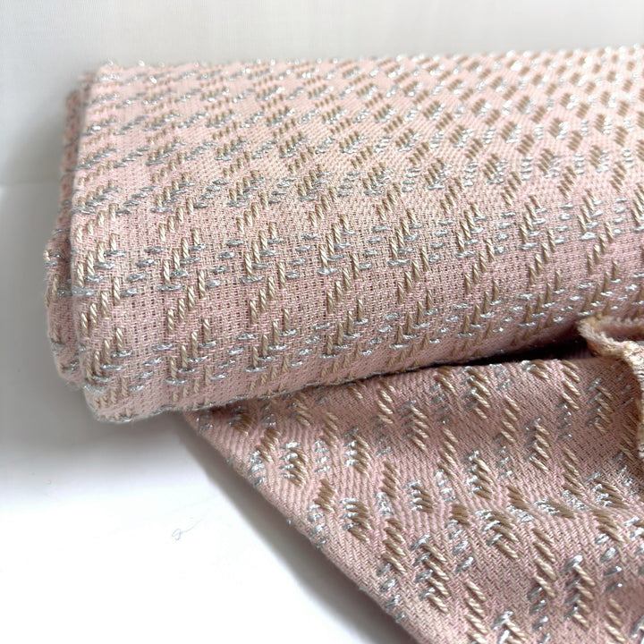 Rolled pink fabric: the raised weave and the silver threads