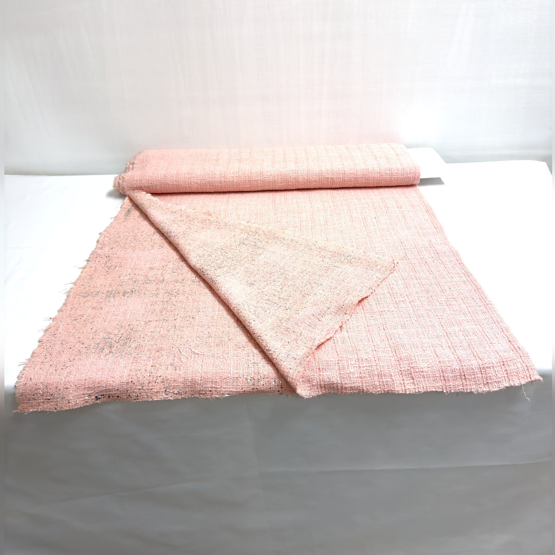 Pink fabric with silver sequins, on the roll and laid out on a white background