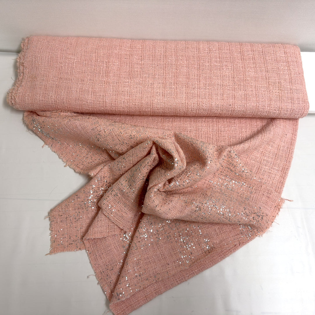 Tessuto rosa con paillettes drappeggiato, per mostrarne la morbidezza e i riflessi