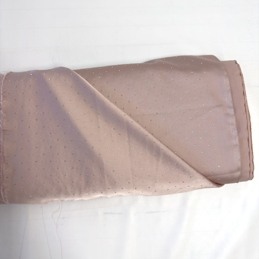 Pink pure silk fabric with silver rhinestones, folded on the roll