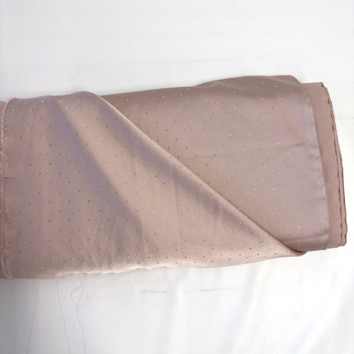 Pink pure silk fabric with silver rhinestones, folded on the roll