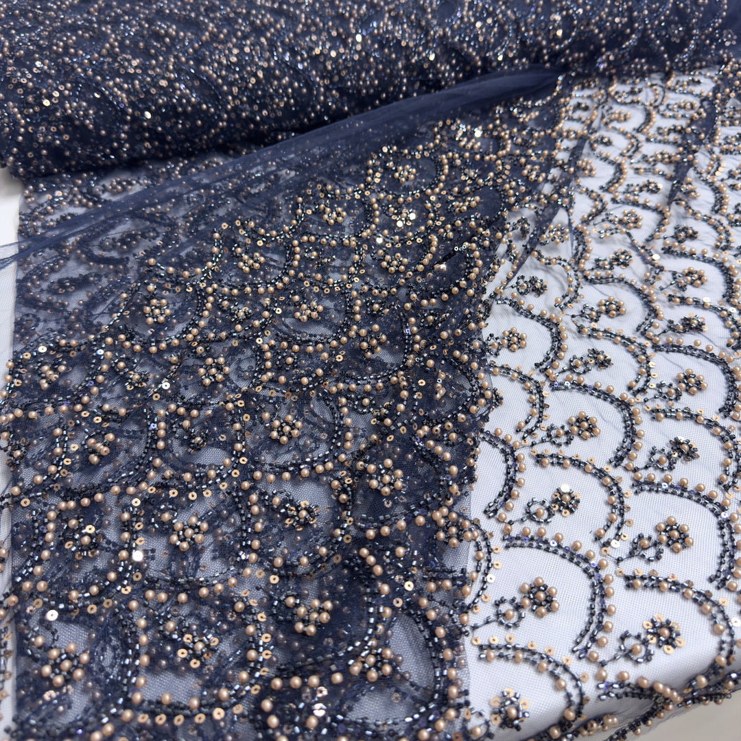 Tulle blu scuro ricamato con perle e paillettes, in rotolo e steso su sfondo bianco