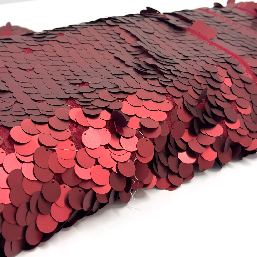 Detail of the round red sequins, about 2 cm across, each sewn onto the red tulle through a small hole