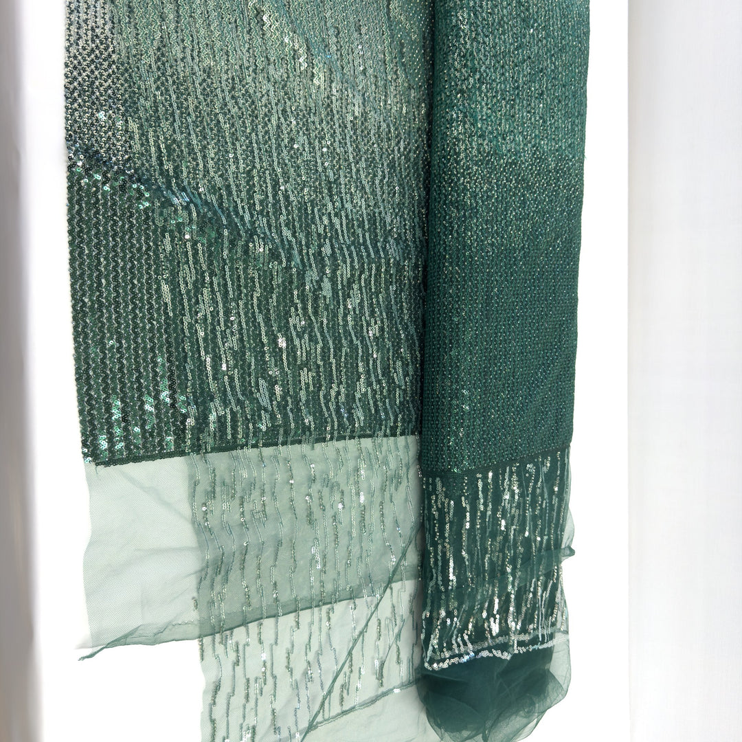 Tessuto in tulle verde con paillettes in degradé: righe di paillettes argento che si infittiscono fino al verde