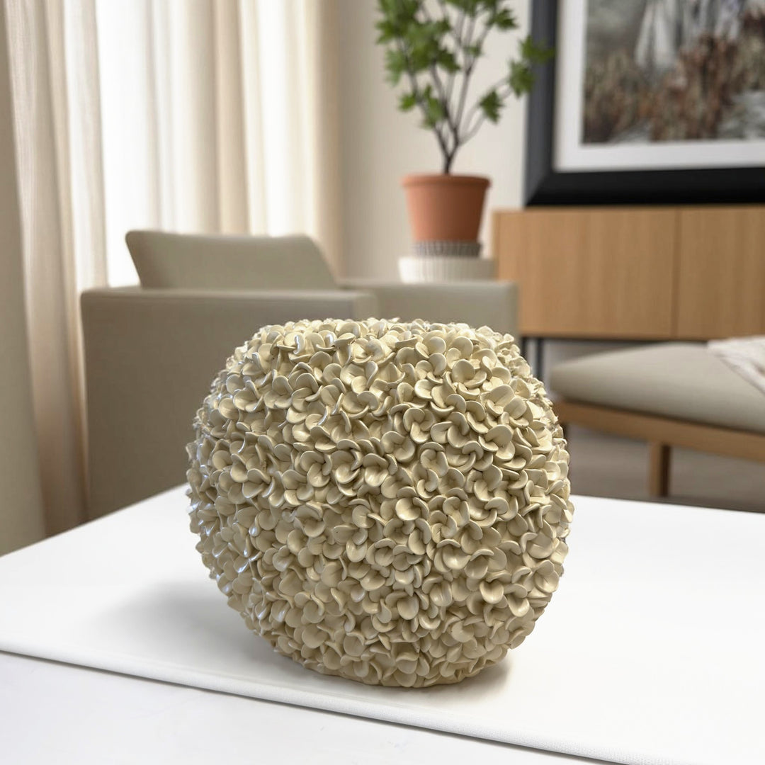 Vaso decorativo con fiori in rilievo color avorio su un tavolo bianco in soggiorno: il vaso è fotografato davvero, la stanza è un'ambientazione ricostruita